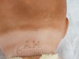 a doll with a bandage around it ' s neck on a bed