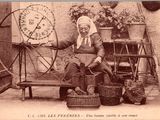 une vieille photo d'une femme assise sur un banc devant un rouet