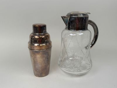 un shaker argenté à côté d'un shaker en verre transparent