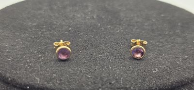 une paire de boucles d'oreilles en améthore sur un fond noir
