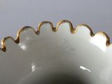 a close up of a white vase with gold trim