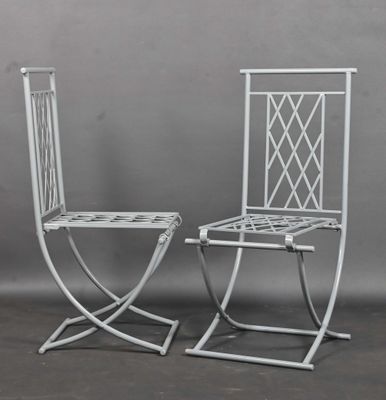 une paire de chaises en métal blanc avec des dossiers en treillis, sur fond gris