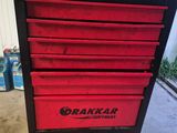 a close up of a red tool box on a cart in a garage