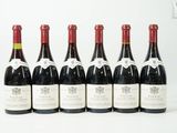 six bouteilles de vin sont alignées sur une surface blanche