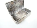 a small silver box with a handle on a white surface
