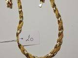 a close up of a gold necklace on a white surface