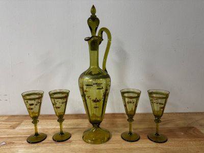four glasses and a decanter sitting on a table
