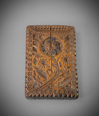 une plaque en bois ornée d'un motif de feuilles et de fleurs