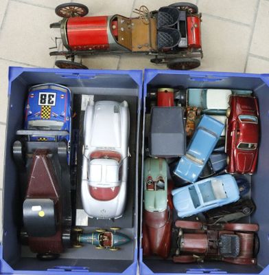 two blue boxes with toy cars in them on a tile floor