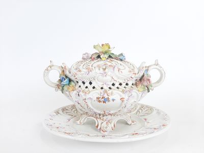 a white teapot and saucer on a saucer