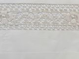 a close up of a white table cloth with a lace border