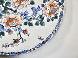 a white plate with blue and orange flowers on it