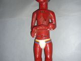 une statue en bois rouge représentant un homme torse nu