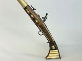 un pistolet à silex ancien, en laiton et plaqué laiton, muni d'une crosse en bois