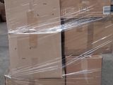 une palette remplie de cartons posée sur une autre palette dans un entrepôt