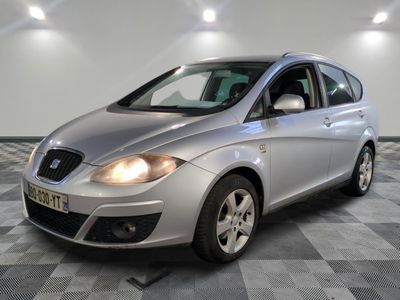 la petite voiture argentée est garée dans une pièce au sol en damier