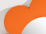 an orange flower shaped mirror hanging on the wall