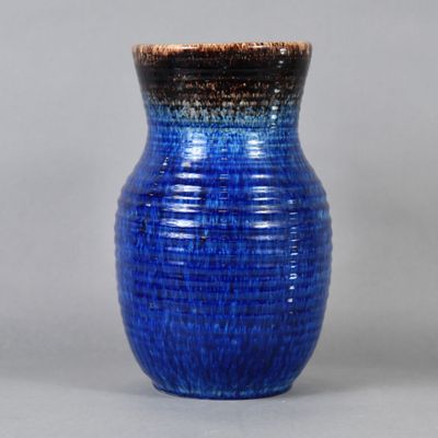 a blue vase that is sitting on a table