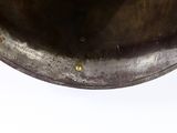 a large metal bowl with a handle on a white surface