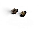 a pair of black and gold earrings sitting on top of a white surface