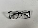 des lunettes noires aux verres transparents posées sur une surface blanche