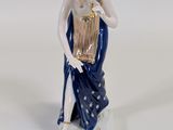 figurine of a woman holding a basket and a bird