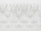 six verres à vin transparents posés les uns à côté des autres sur une surface blanche