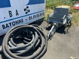 une remorque à laquelle est raccordé un tuyau, à côté d'une remorque à laquelle est attelée une autre remorque