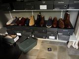 Plusieurs paires de chaussures sont alignées sur une étagère dans un placard