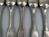 many spoons and spoon spoons lined up on a table