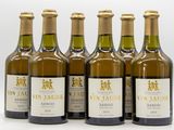 six bottles of wine are lined up in a row on a white surface