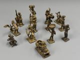 six bronze figurines of people playing musical instruments on a white surface