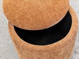 an image of a round ottoman with a lid on a concrete floor
