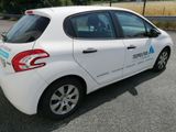 a small white car parked on the side of the road