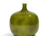 a green vase that is sitting on a white surface