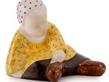 a small figurine of a woman sitting on the ground