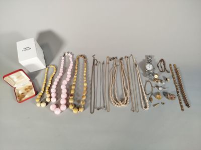 un tas de bijoux posés sur une table, à côté d'une boîte