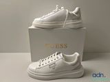 baskets en cuir blanc avec un logo doré sur le côté