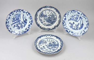 quatre assiettes bleues et blanches ornées de motifs, posées sur une table