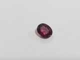a close up of a pink sapphire stone on a white surface
