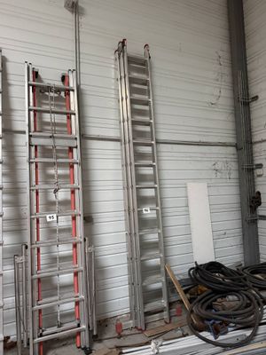 several ladders are lined up in a room with a lot of wires