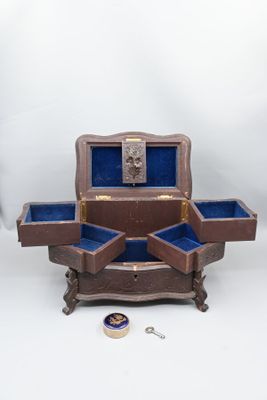une petite boîte en bois comportant deux compartiments ouverts, posée sur une table