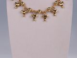 an image of a gold necklace on a mannequin