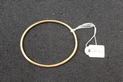 a gold ring with a white tag attached to it