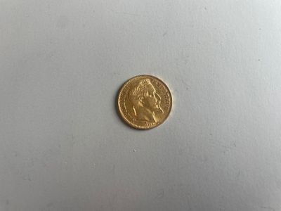 gros plan d'une pièce d'or sur une surface blanche