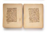 an open book with arabic writing on it sitting on top of a table