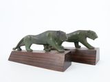 two figurines of two lions on a wooden base