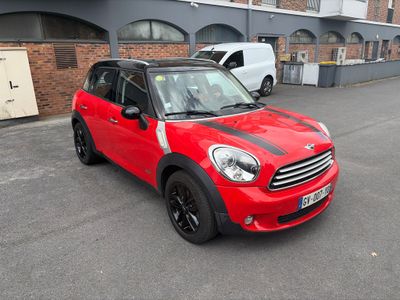 a red mini cooper parked in a parking lot
