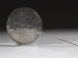 une cuillère en argent posée sur une table blanche