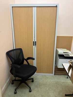 une chaise de bureau noire placée devant une porte coulissante